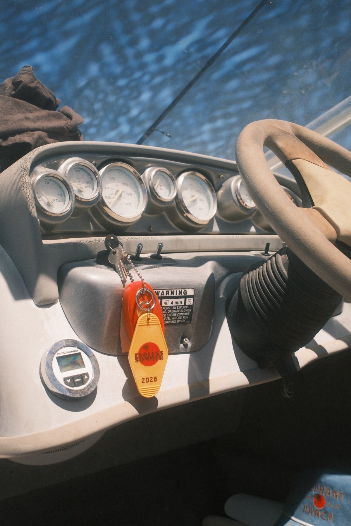 Endless Summer 2026 keychain hanging from the ignition on a boat dashboard